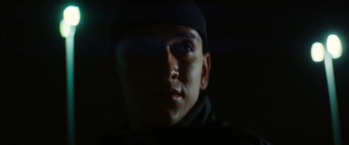 A man is standing outdoors during the night time
