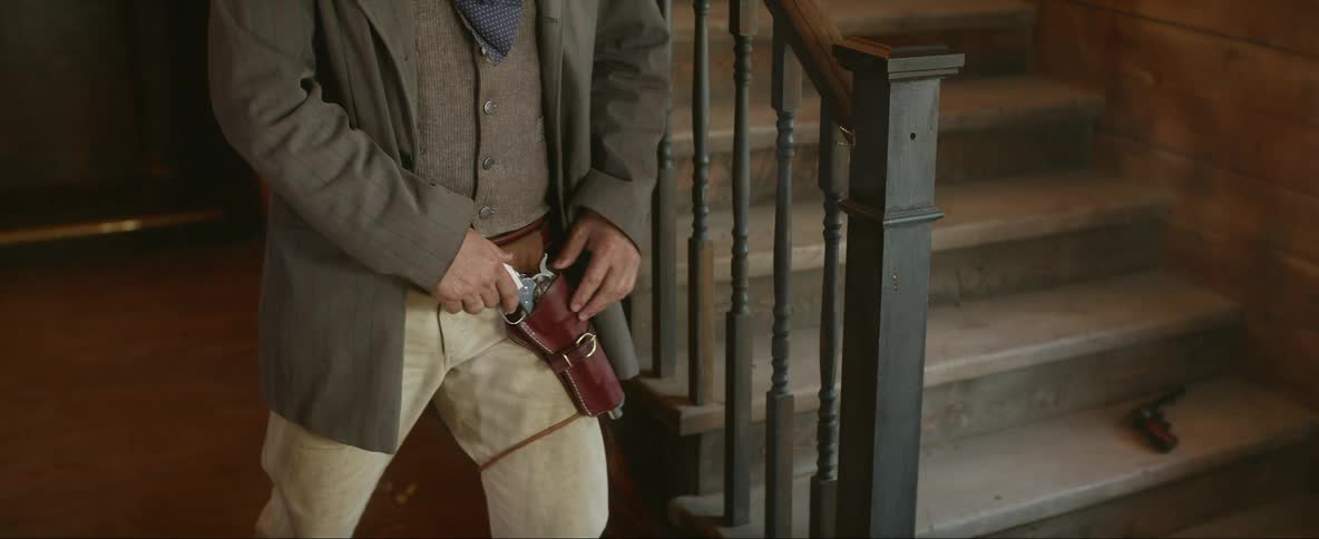 A man reaches for his gun while another man falls down the stairs