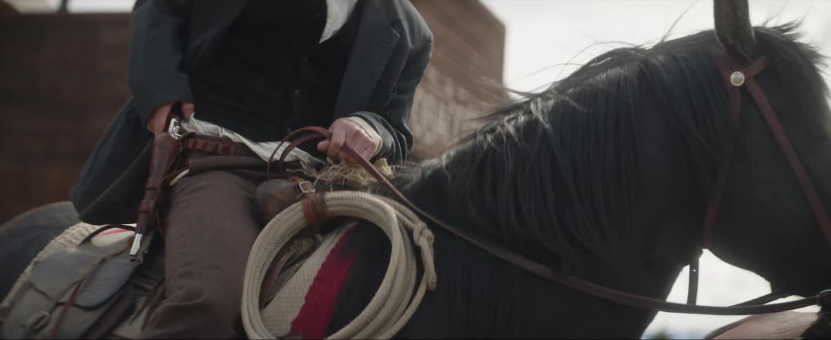 A man on a horse pulls a gun from its holster