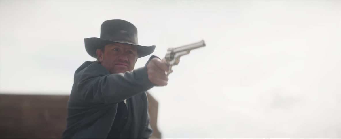 A man on the horse takes a gun from a holster on his lip