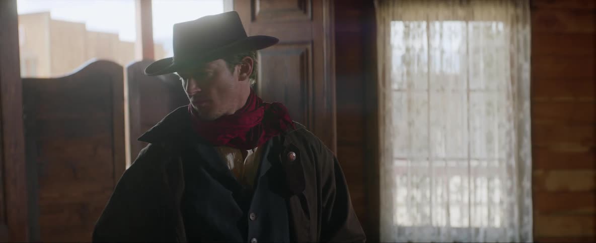 Cowboy holsters his gun before leaving a bar on a wild west town
