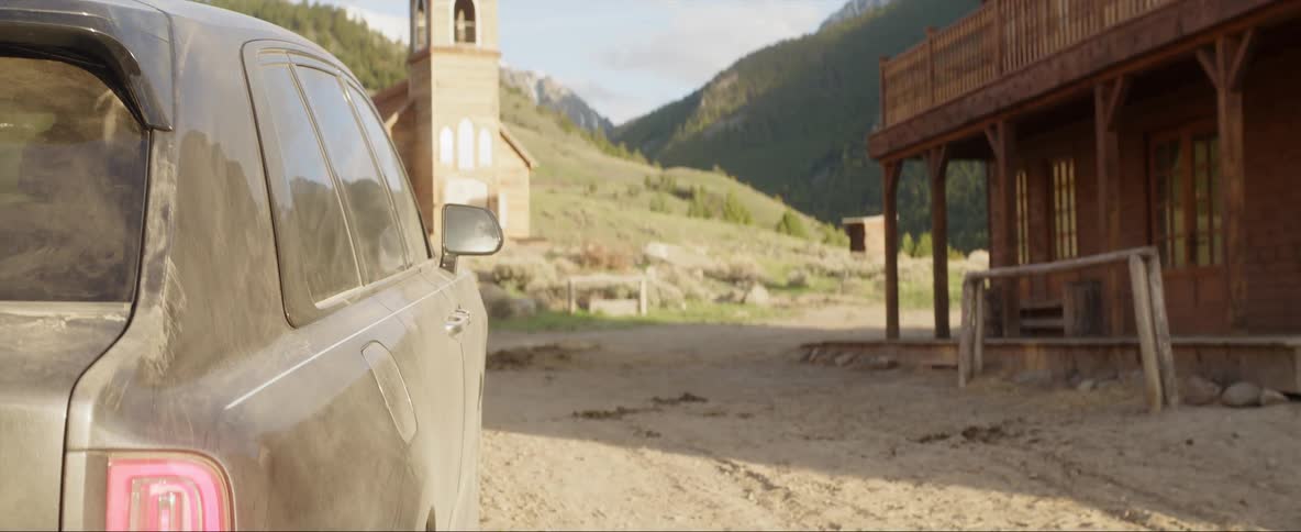 Woman carrying a rifle and a cowboy board a modern car and drive away on a wild west town