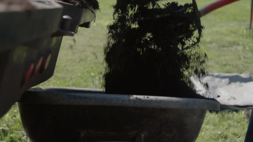 Dirt is being shoveled into a bin