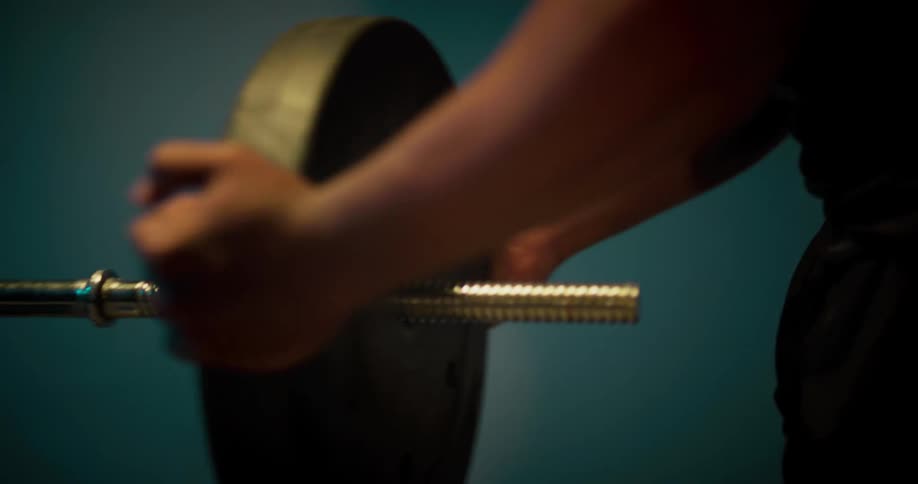 Strong muscular young man put weights on a bench to workout