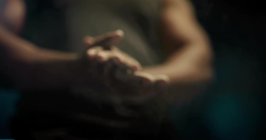 A man is clapping his hands and standing indoors