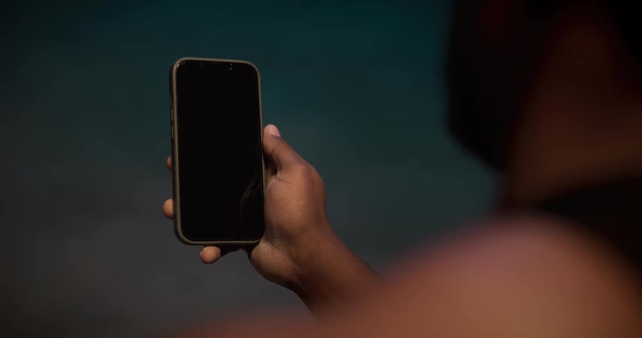Close up of a man using his thumb to gesture over the screen of a smartphone