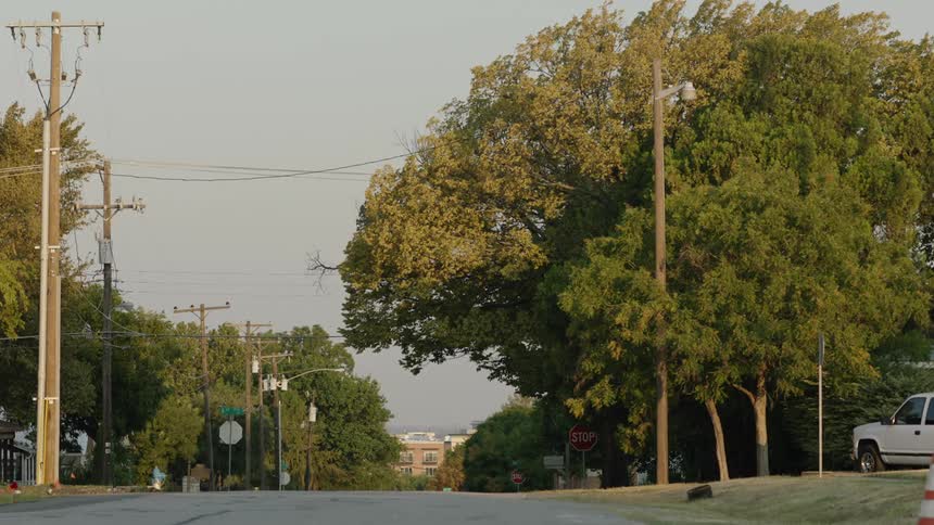 A wide shot of an empty suburban street in a small American town