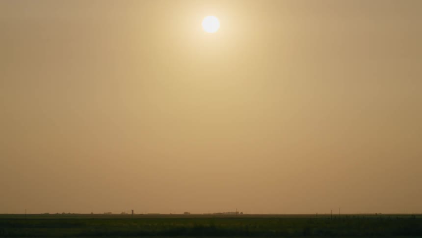 A view of the sun setting over a vast, rural, Texas landscape
