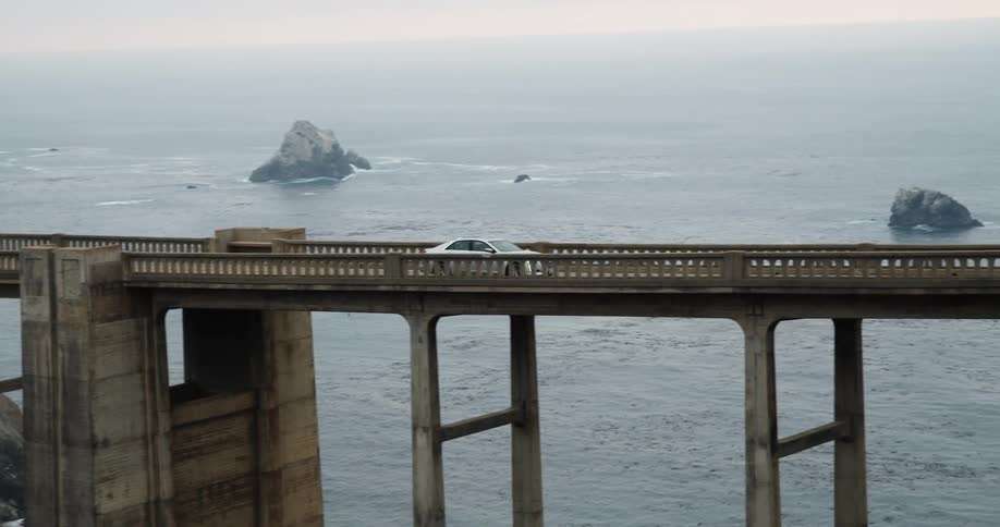 A car driving on a bridge over water