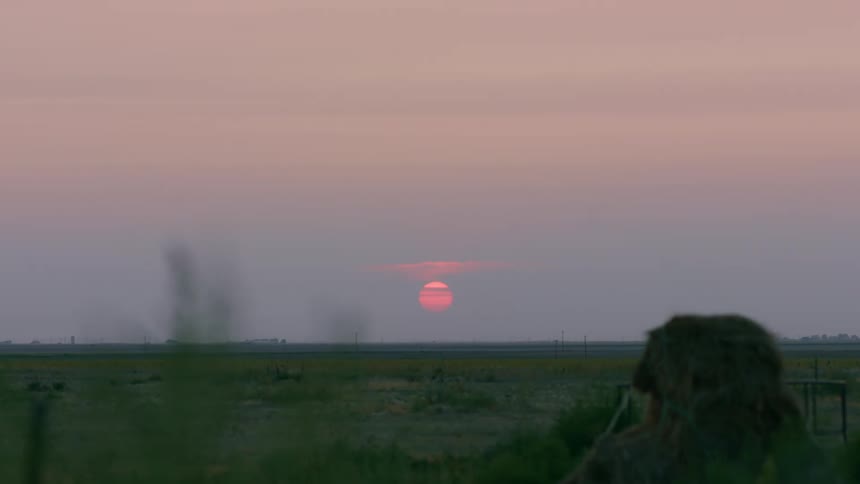 A dramatic sunset dropping below the horizon on a peaceful prairie in Texas