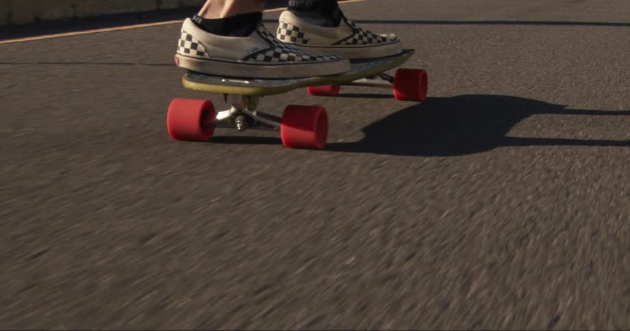 A person skateboards down a road