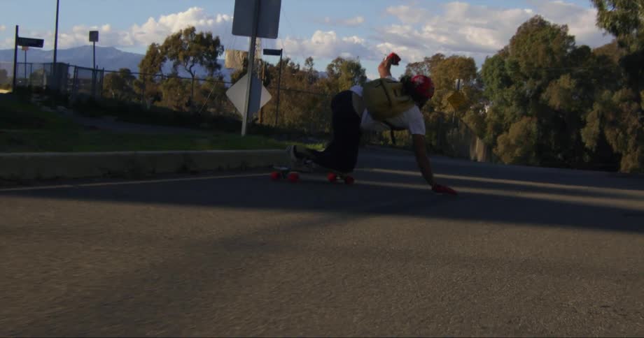 A man long boarding down a mountain