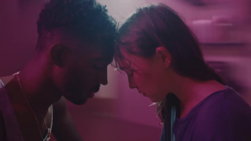 Two people lean their heads together while the camera spins