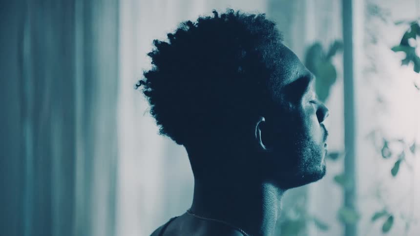 A man stands still with his eyes closed