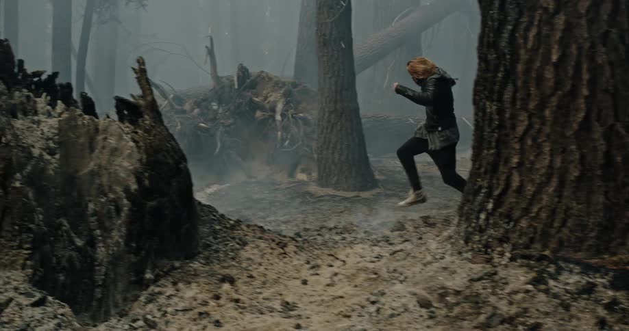 A man runs through the burning forest