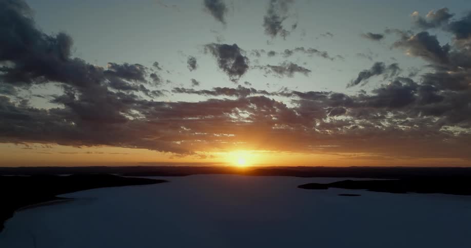 Golden sun setting on the horizon over the white plains of a desert