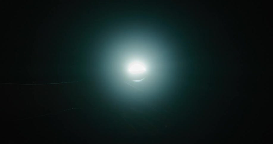 A person waves their hand in front of a light
