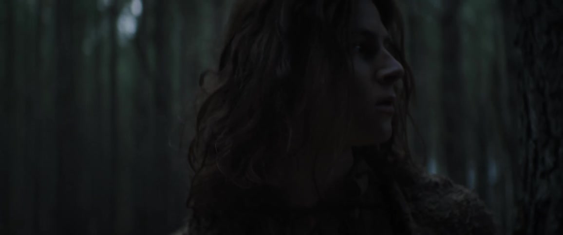A young man paces around a forest and looks lost