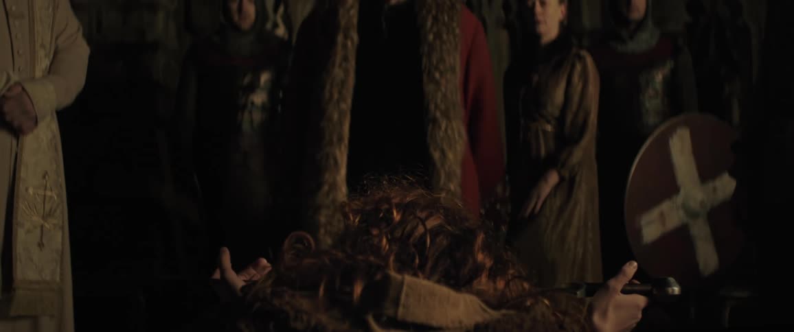 A medieval king stands from his thrown and crowns a kneeling boy