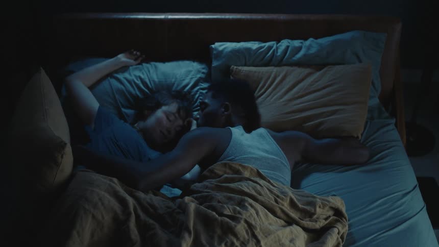 Young couple getting comfortable while sleeping together in the bed at home