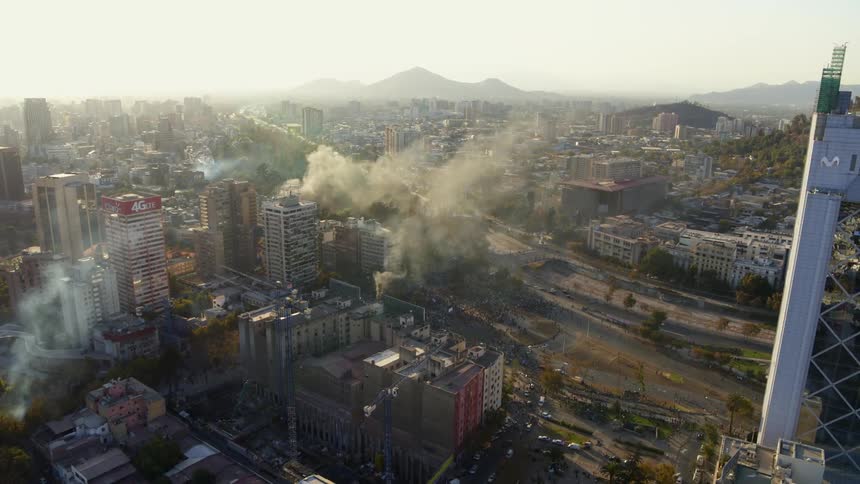 Extreme wide aerial of protests overrunning Santiago