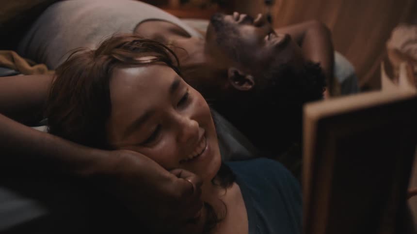 A couple laugh while reading a book together