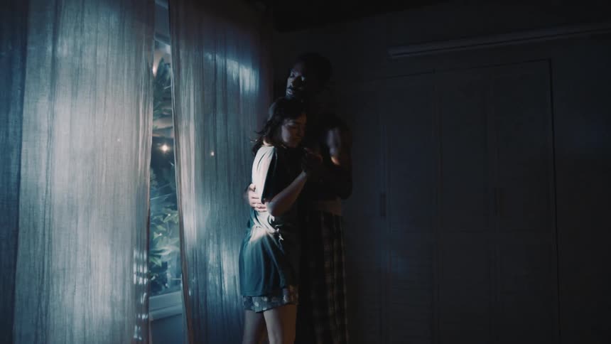 A man and woman slow dance at home