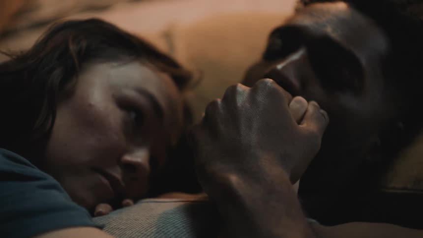 A couple are laying in bed together