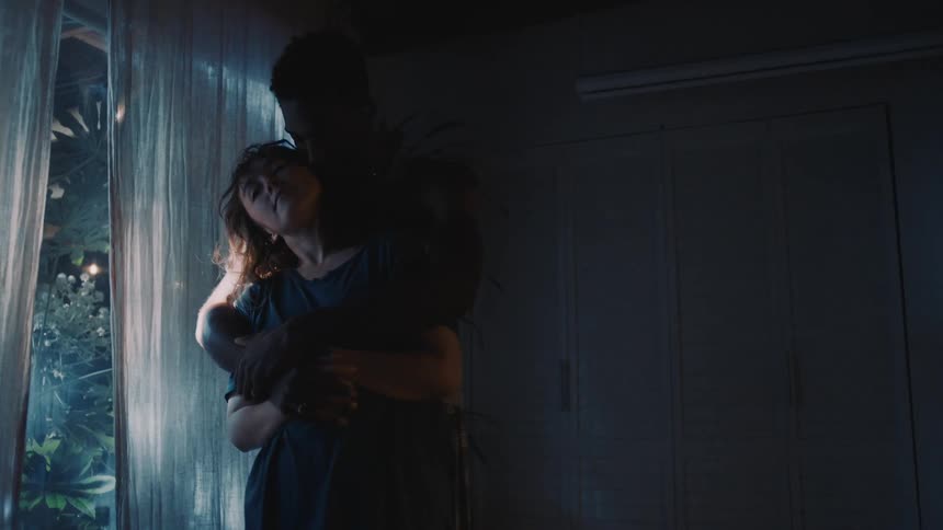 Young couple wearing pajamas dancing slowly in the bedroom at home