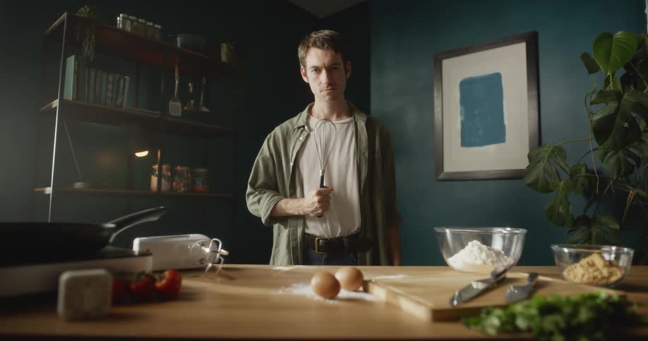 A man is standing by his table and is preparing food