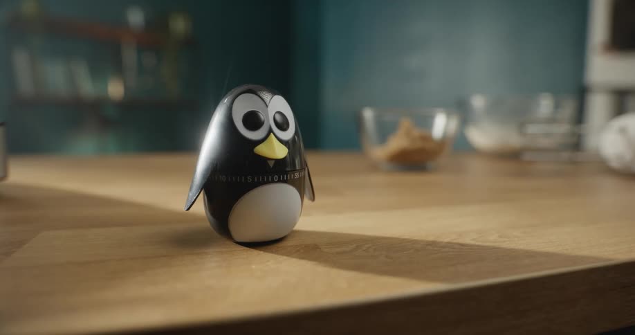 Wood penguin with large eyes sitting on table in kitchen