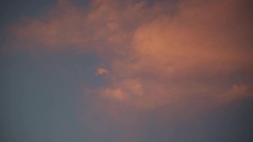 Pink clouds floating in the blue sky at evening