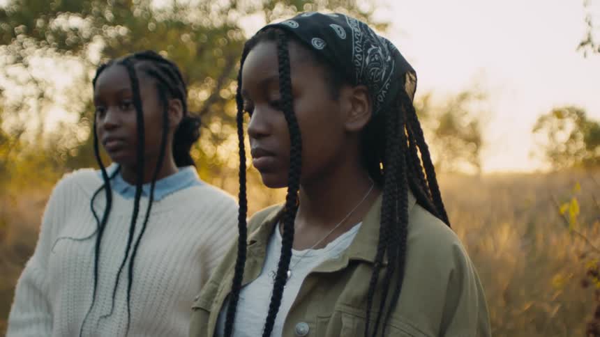 Two women nod while standing together