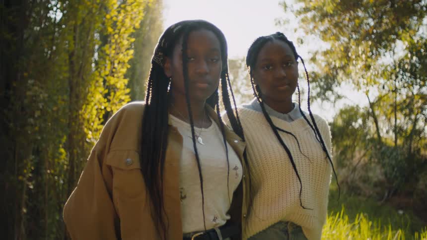 Two sisters pose in the woods