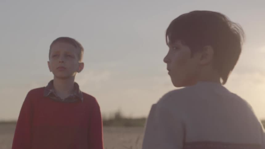 Two children turn their heads towards something