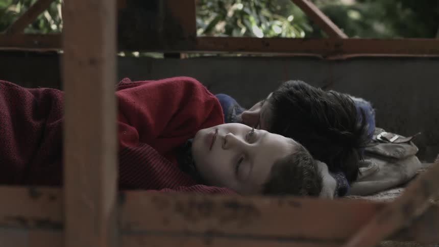Two children sleep together in bed