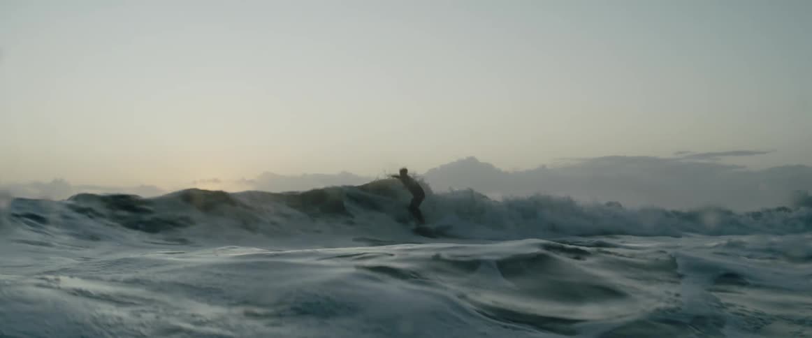 A surfer tries to hold on while riding a strong wave