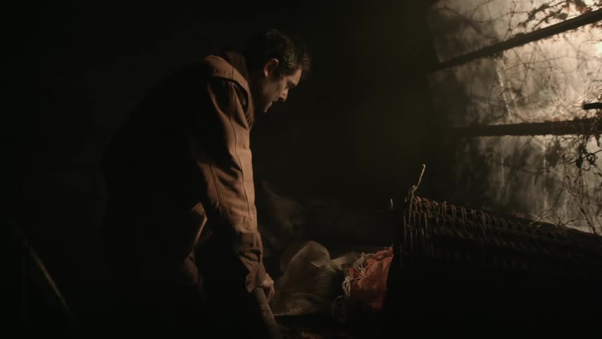 Weak powerless man reclines on a table inside a dirty room on an abandoned building
