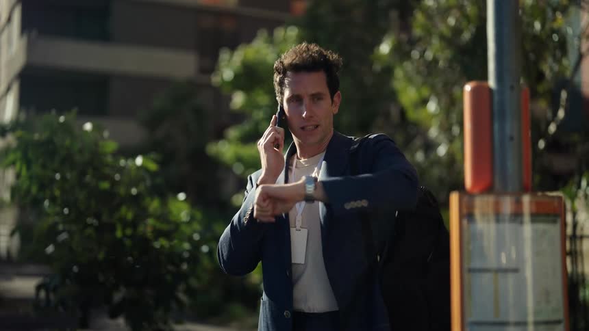 A man talking on a phone standing outdooors
