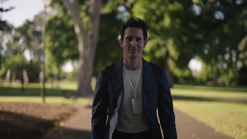 A man walking down a sidewalk in a town