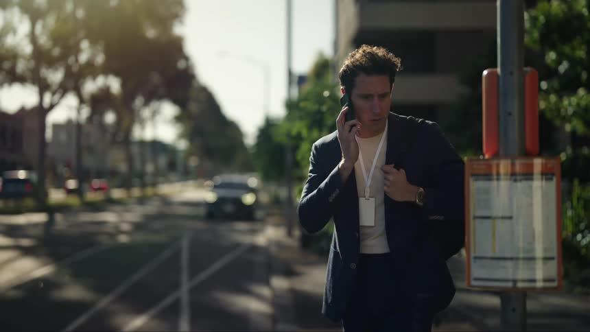 Man talks on cellphone while checking bus schedule