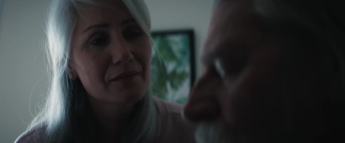 Elderly woman gives his husband a gentle kiss on the forehead
