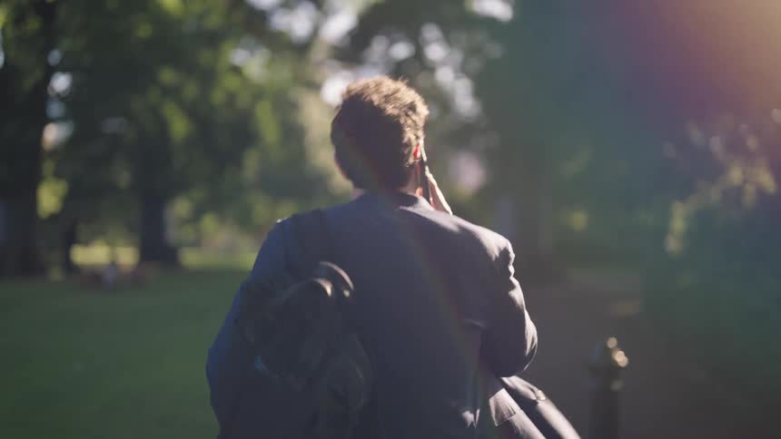 A man walking outdoors with a smarpthone