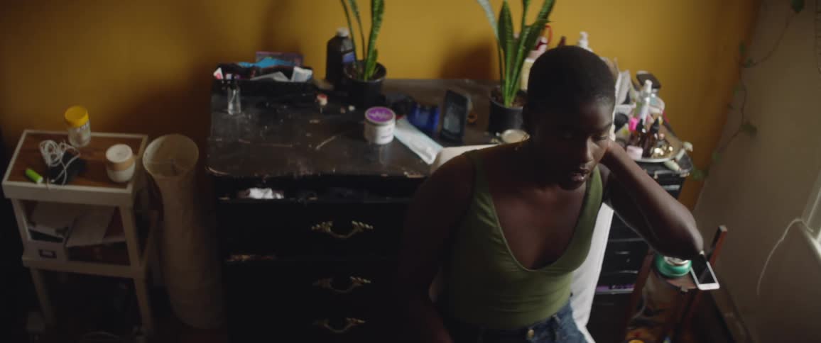 Young woman sitting on her room talking to someone out of frame