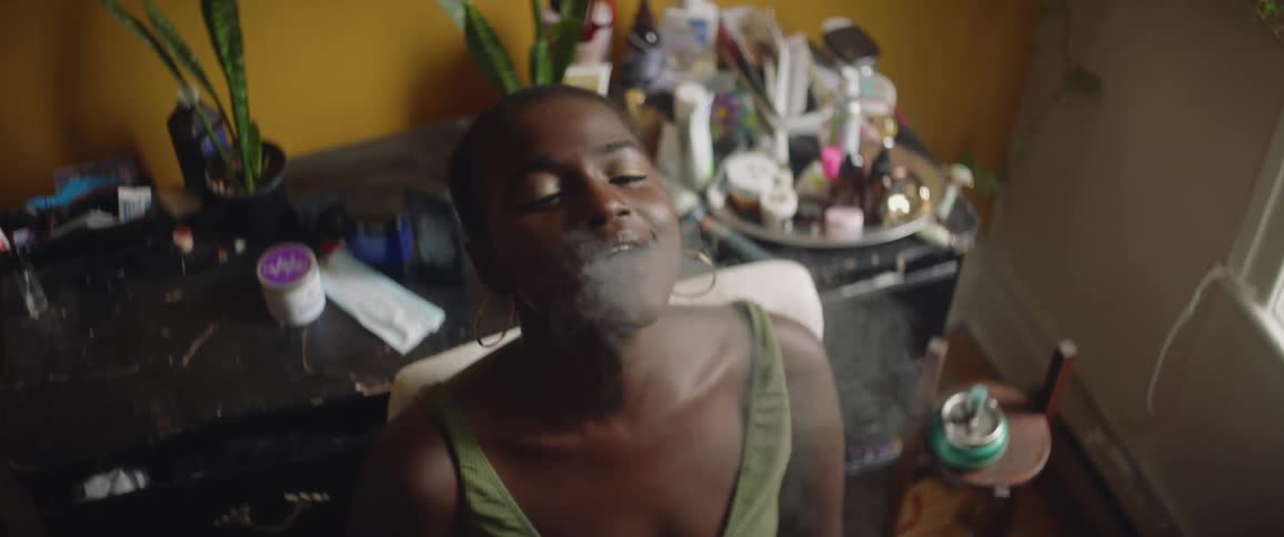 A woman nods her head while smoking drugs