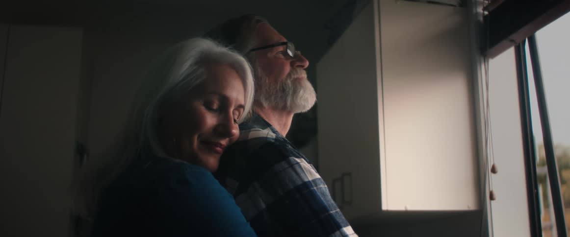 A couple hug by the window