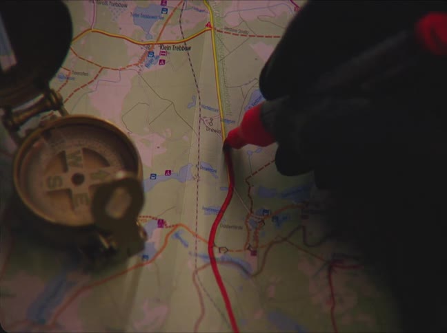 A person is marking a map with a marker