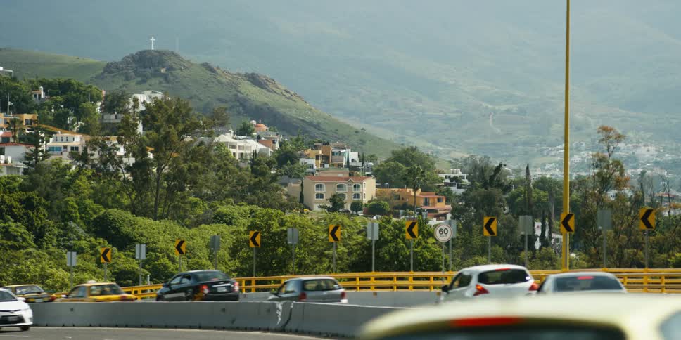Vehicles driving on a street in front of a town