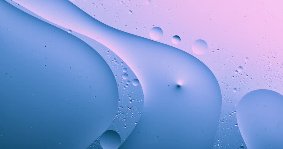 Blobs and bubbles of translucent liquid gently flowing over a blue and magenta background