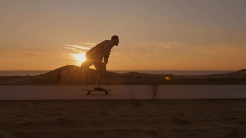 A man is skateboarding on the boardwalk